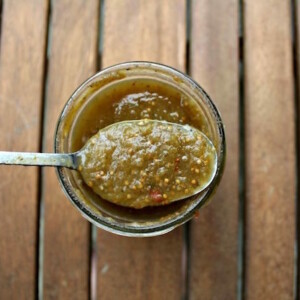 Opening up a jar of home canned salsa verde to show the smooth texture and vibrant color.