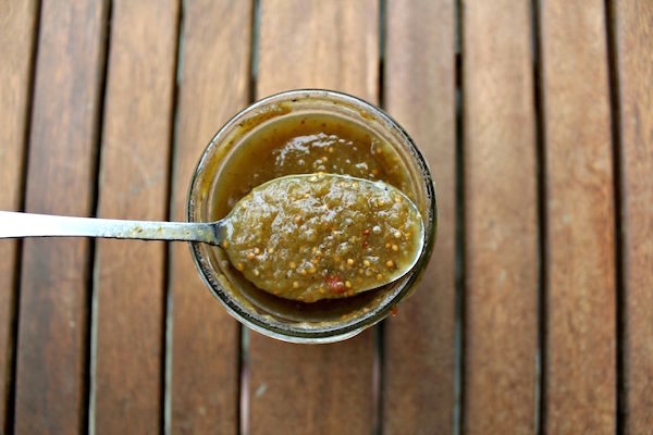 Opening up a jar of home canned salsa verde to show the smooth texture and vibrant color.