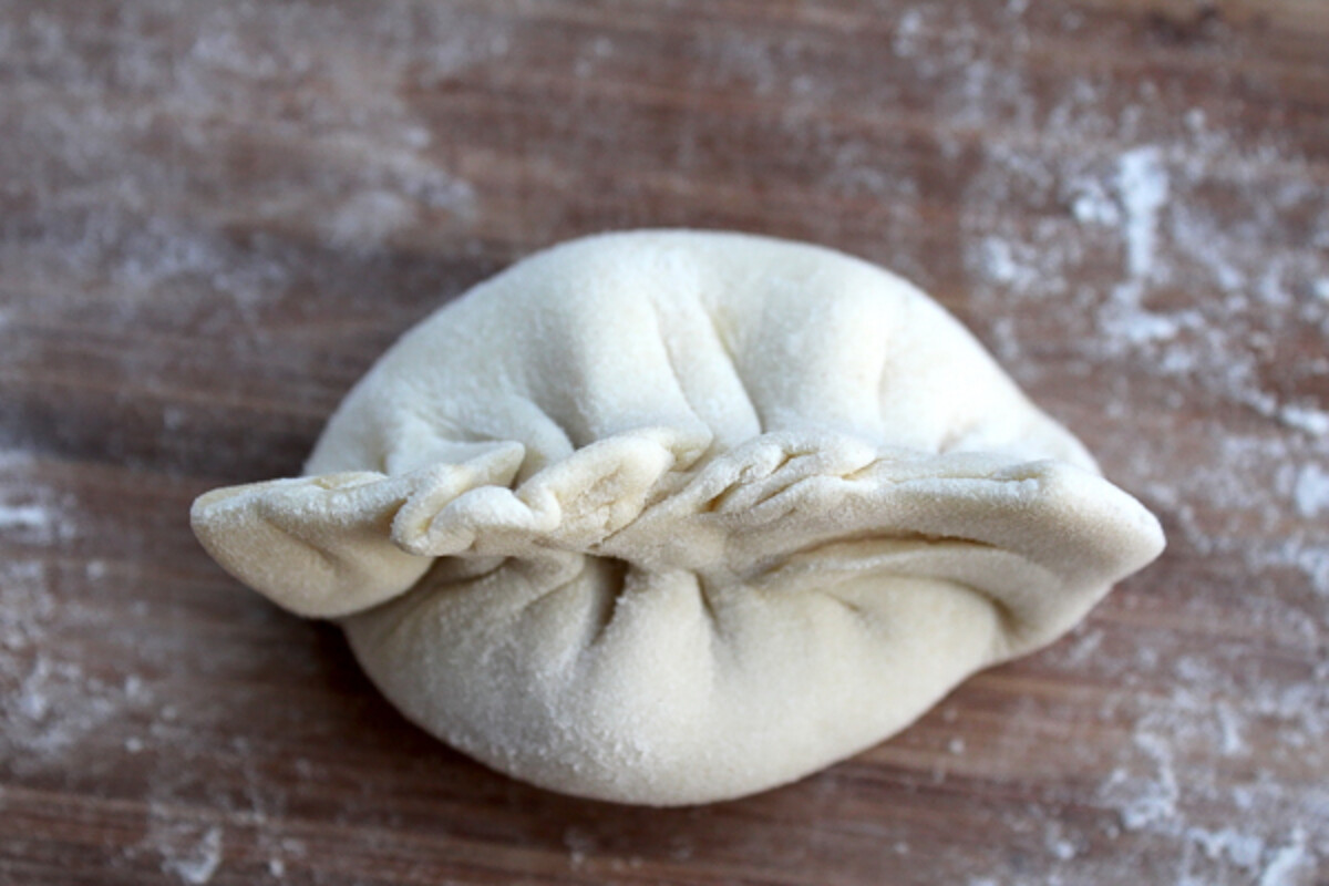 A finished Asian dumpling ready for steaming or pan frying.