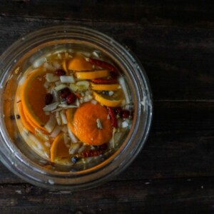 looking into a glass jar filled with fire cider ingredients