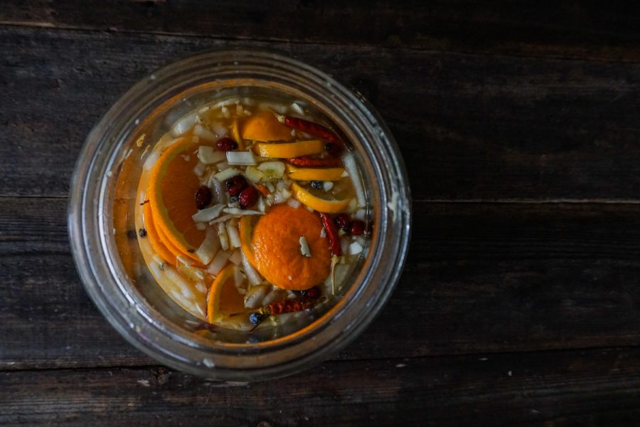 looking into a glass jar filled with fire cider ingredients