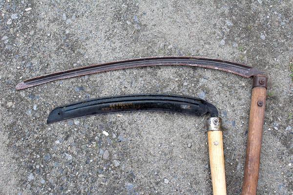 Two scythe blades, one shorter weed blade and a longer grass scythe blade