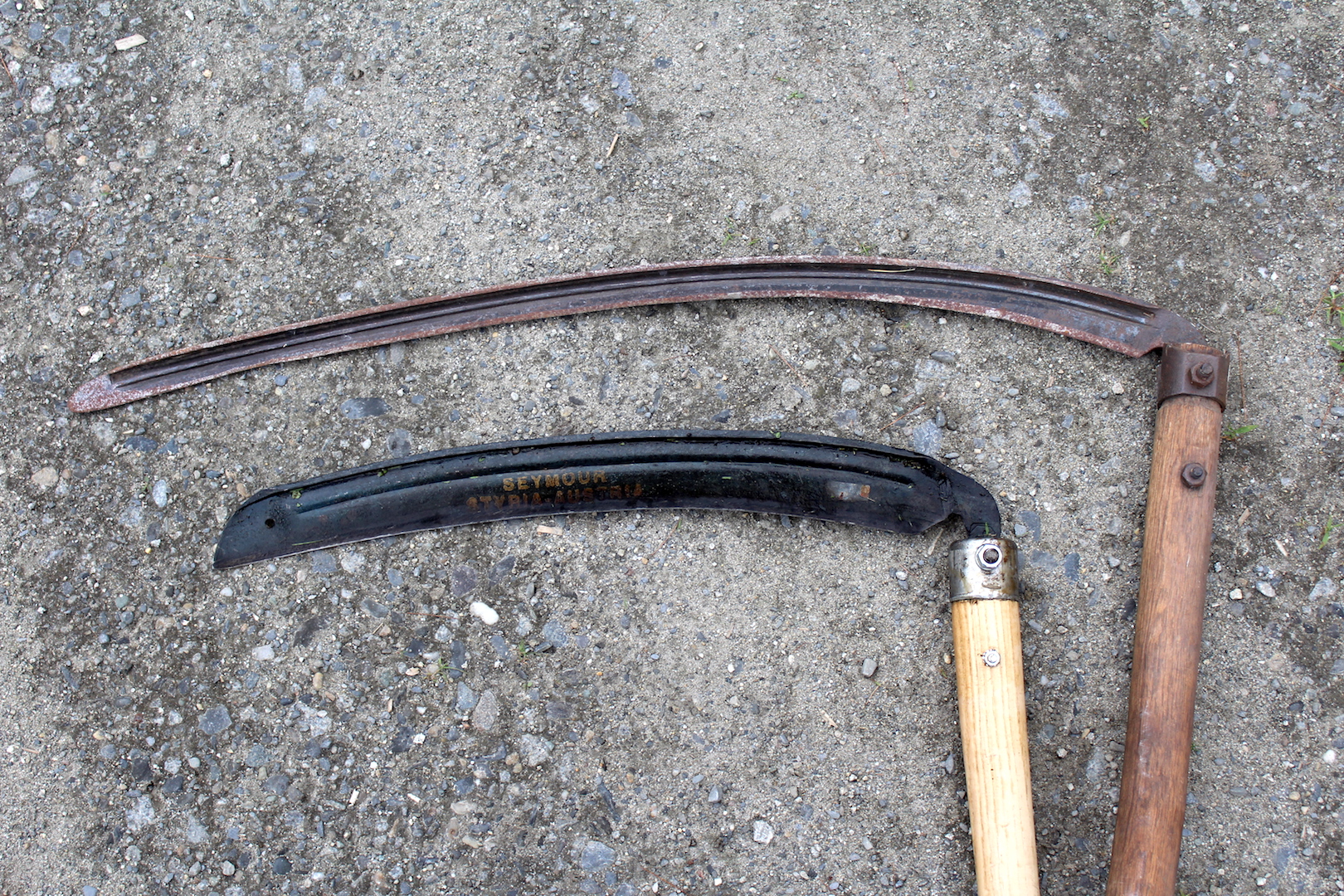Two scythe blades, one shorter weed blade and a longer grass scythe blade