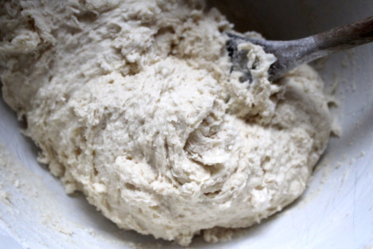 Stirring flour into milk and yeast for amish white bread