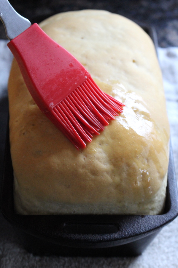 Brushing Amish White Bread with Butter for a soft crust