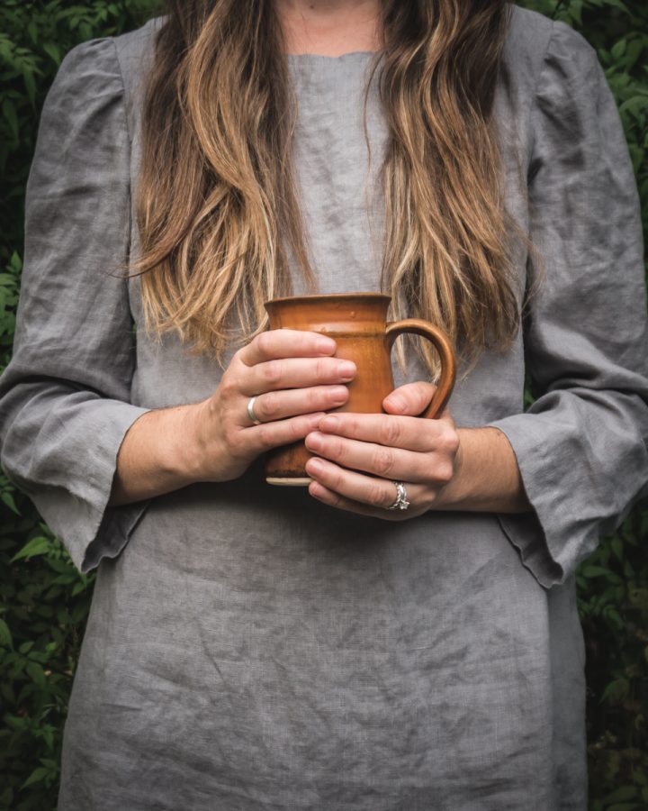 woman holding a brown coffee mug full of homemade bone broth