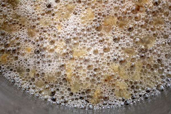 Leaf lard after about an hour and 45 minutes rendering on low. The bubbles have changed character, indicating it's almost finished.