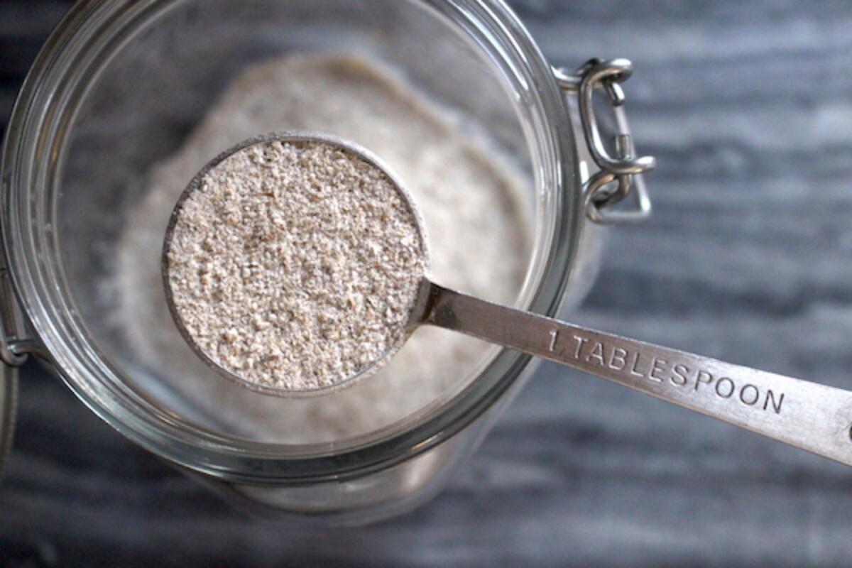 Adding initial flour to a jar to create a rye sourdough starter.