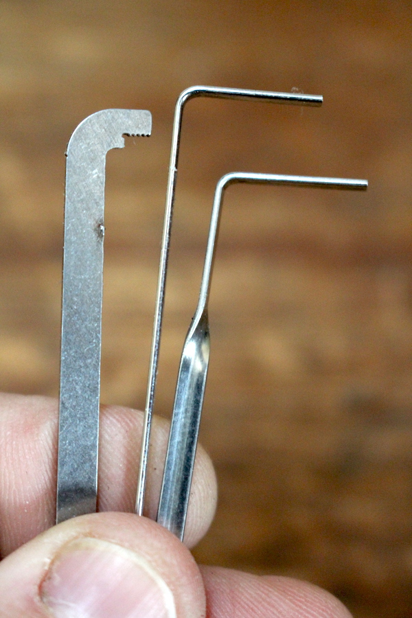 Various tension wrenches for lock picking, the most basic one is in the center.