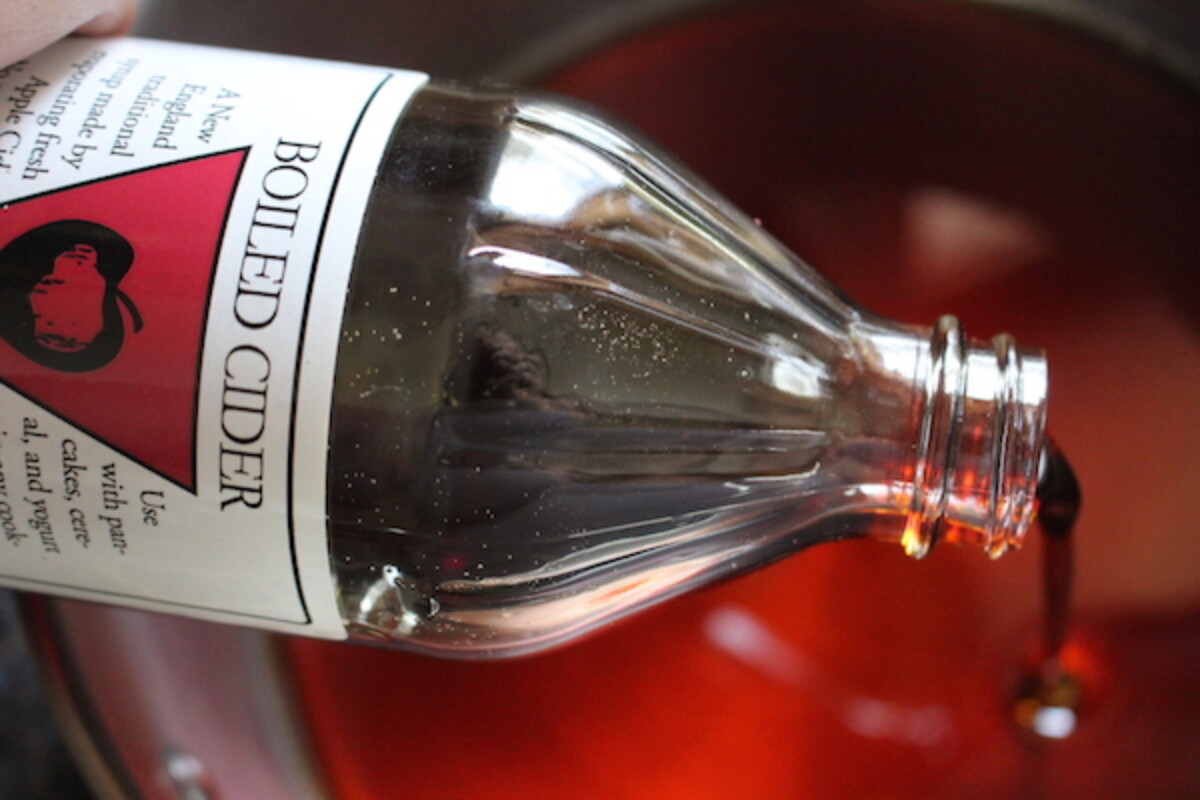 Pouring boiled cider into a pot in an attempt to cook it into granular apple sugar