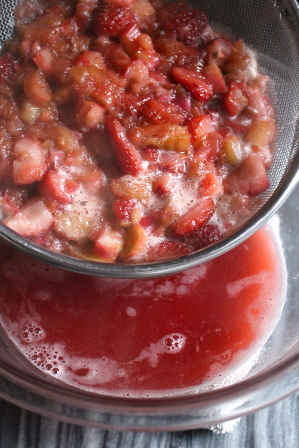 Straining the juice out of strawberry rhubarb jam so that it can cook separately. This will allow the jam to thicken fully without pectin.