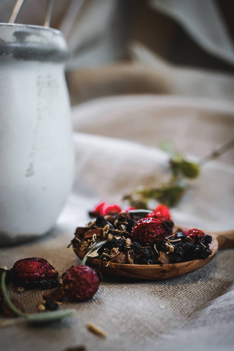 loose herbal tea with rose hips in front of a tea mug