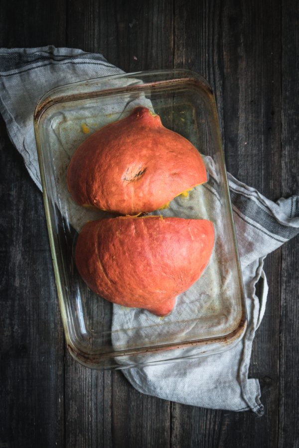 a cut winter squash in a glass baking dish