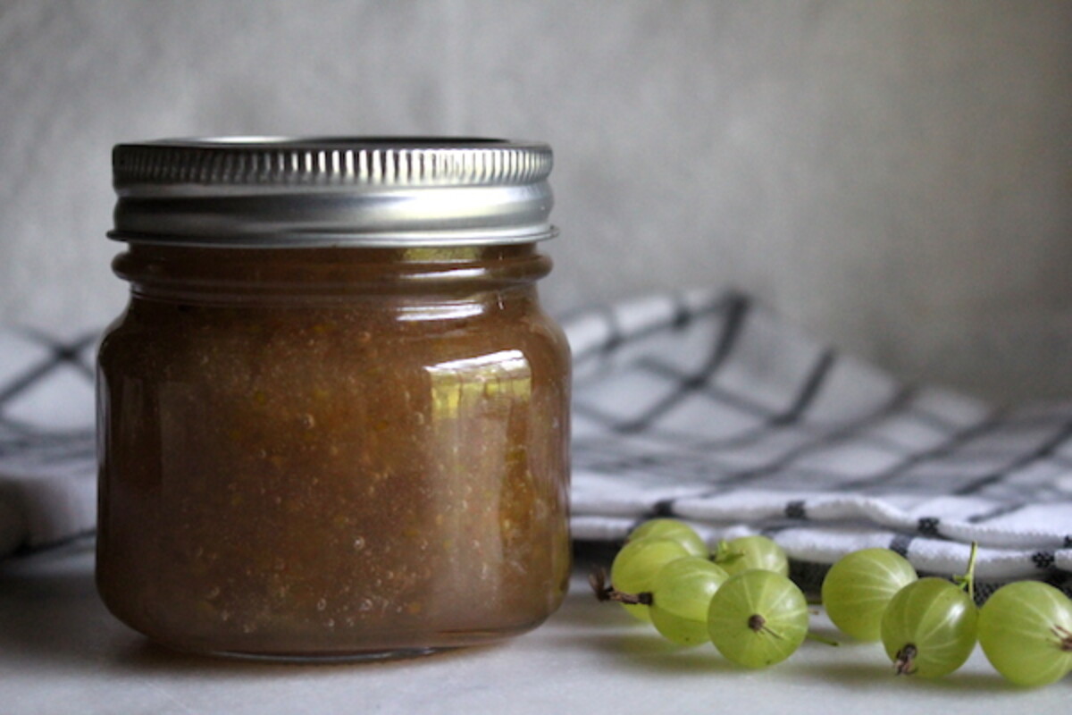 A jar of home canned gooseberry jam, sealed and ready for pantry storage.