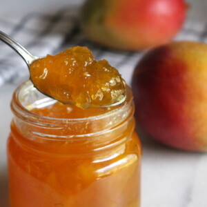 Homemade mango jam on a spoon showing how thick the jam got naturally without pectin.