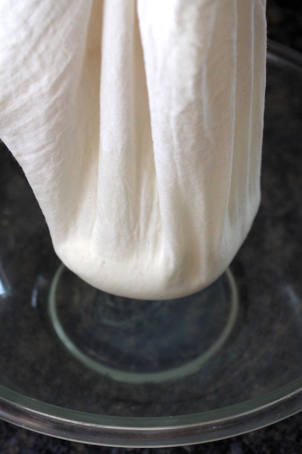 Homemade yogurt cheese hanging in cheesecloth