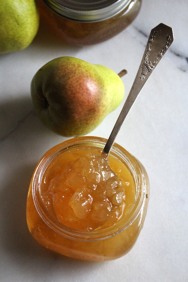 Jar of homemade pear jam open on a table to show the thick texture achieved without added pectin