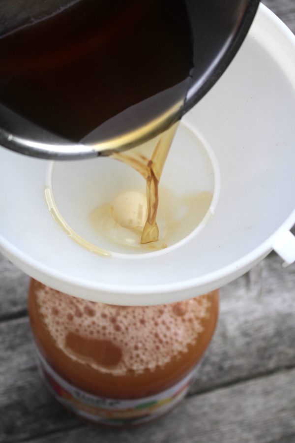 Winemaking additives going into a jug of apple juice before it's fermented into apple wine.