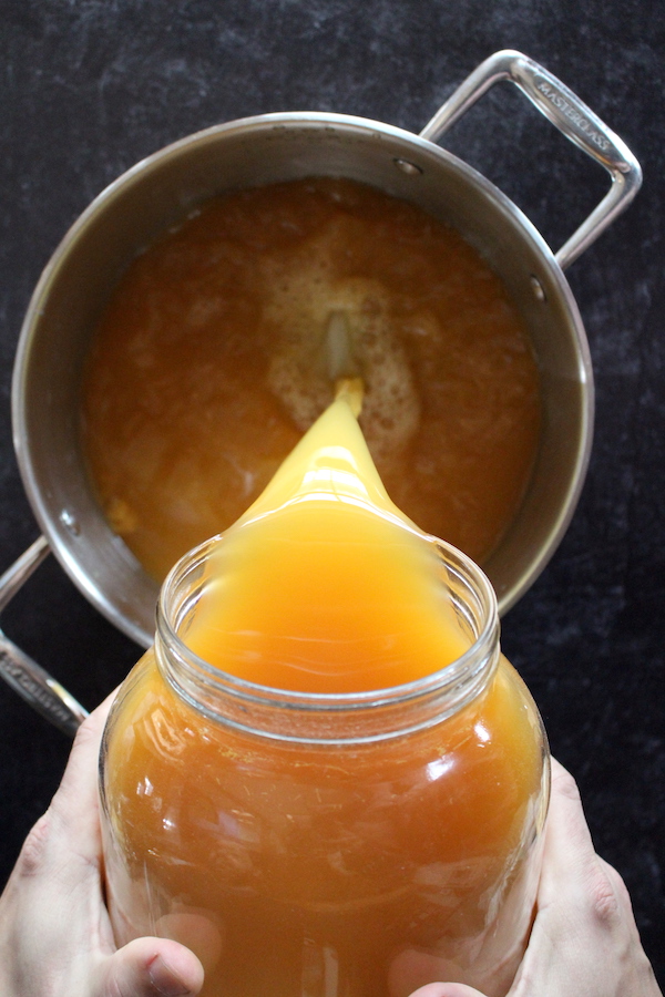 Decanting apple cider vinegar into a pot to pasteurize