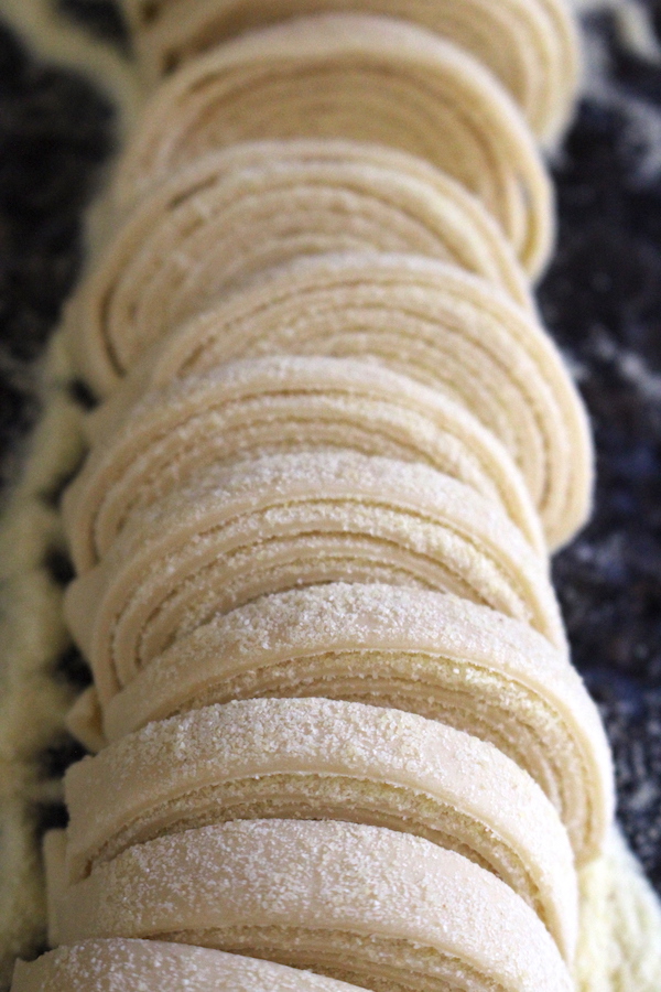 Cutting homemade pasta into noodles