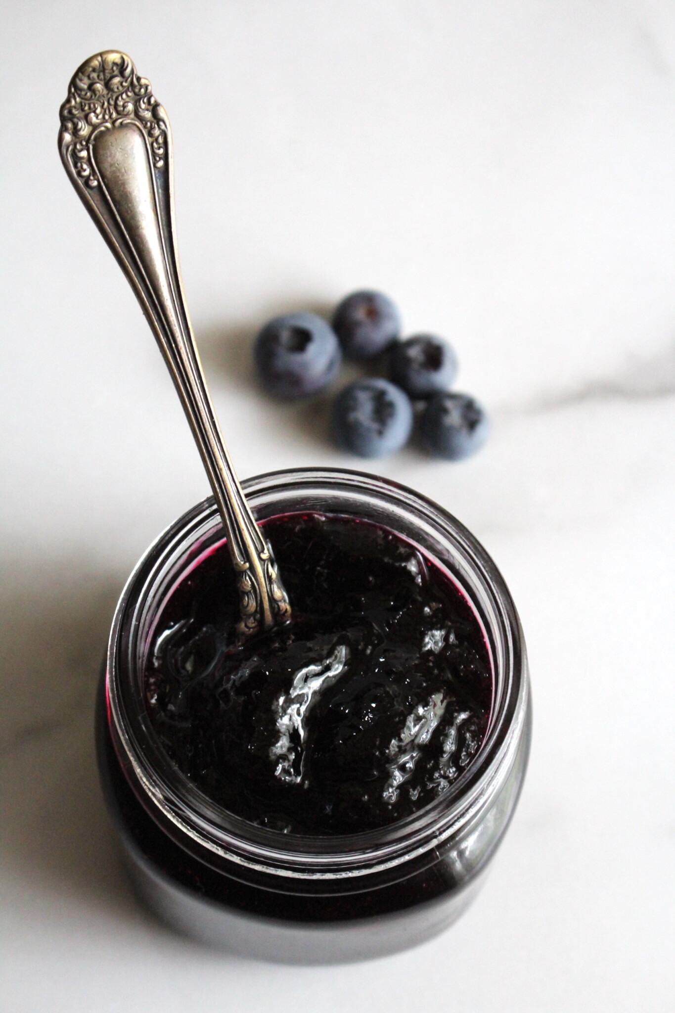 Blueberry jelly in a jar with a spoon