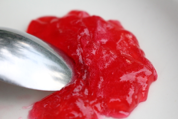 Testing for redcurrant jelly set on a cold plate with a spoon