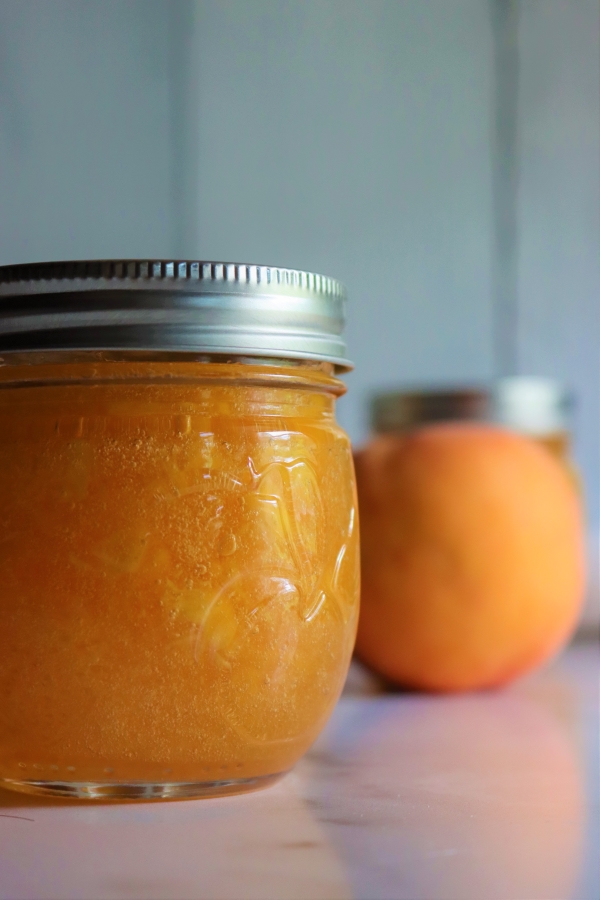 Homemade peach jam has a beautiful orange color because the peaches were treated with lemon juice as they were cut to prevent browning.