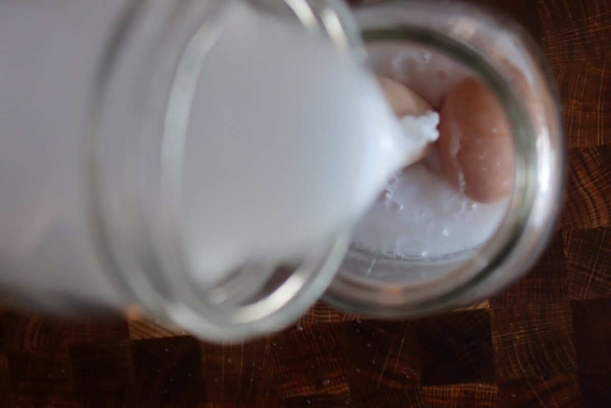 Pouring lime solution over fresh eggs