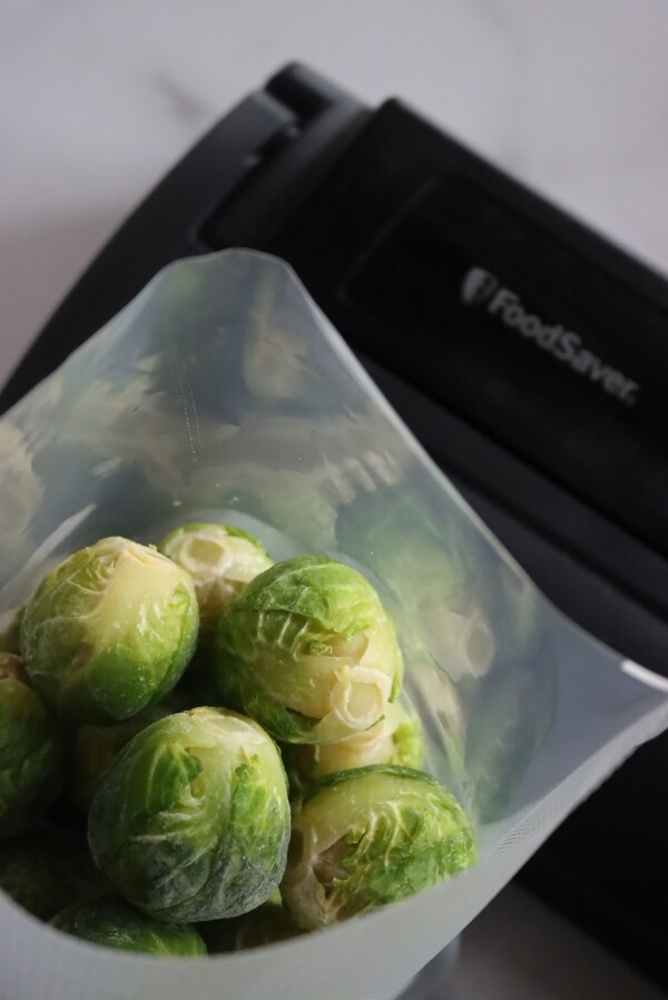Blanched and flash frozen brussels sprouts in a vacuum sealer bag, about to be sealed with my Food Saver Vacuum Sealer.