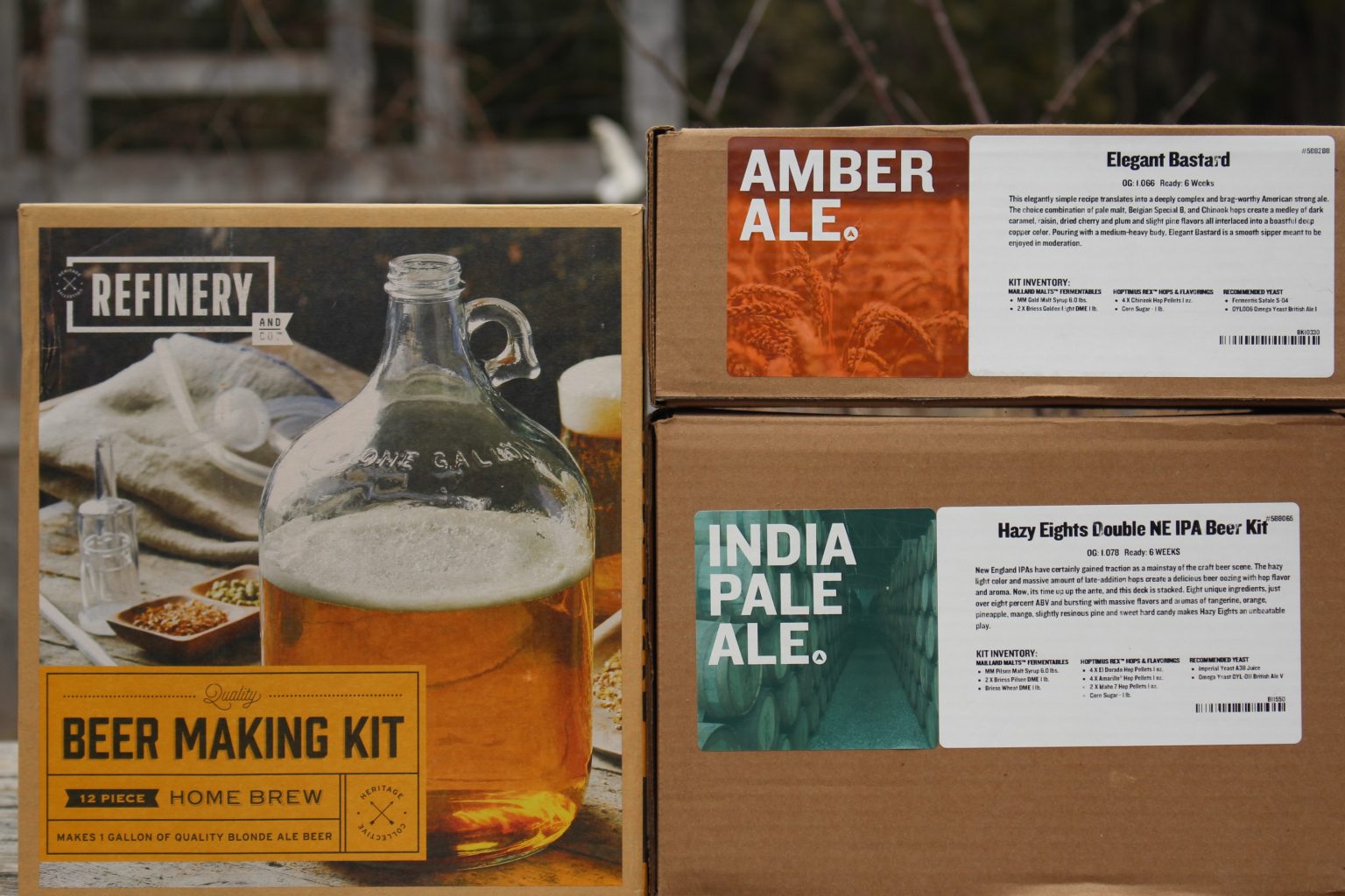 A full beer making kit including equipment (left), and two beer ingredient kits with just hops/malt/yeast (right).