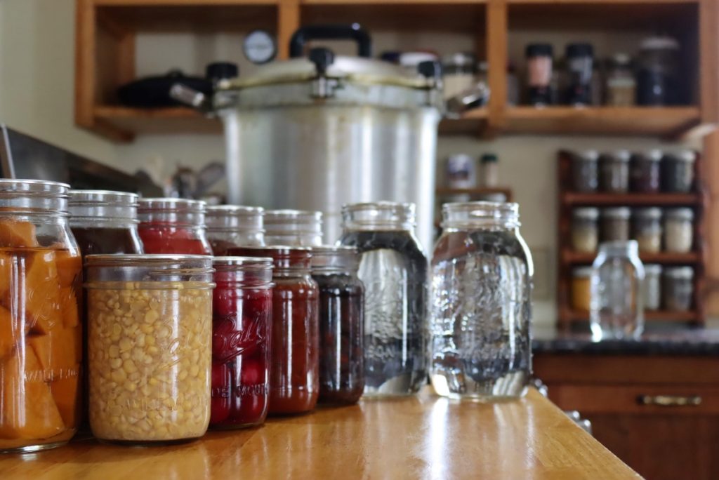 Pressure Canning ~ A display of foods that need to be pressure canned, along with a pressure canner.
